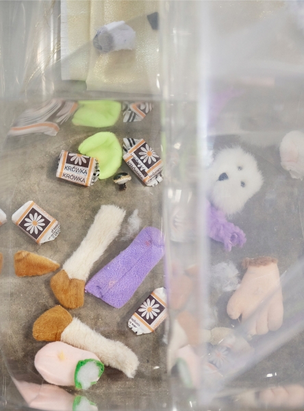 Close-up photo of scattered Polish fudge wrappers, candies, and limbs and heads of miniature stuffed animals