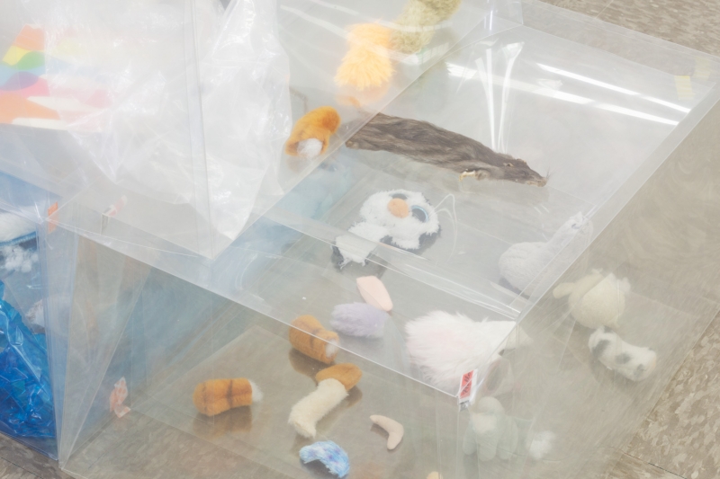 Close-up photo of scattered Polish fudge wrappers, candies, and limbs and heads of miniature stuffed animals